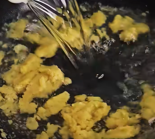 Gradually pour in the water (or chicken stock), whisking constantly to avoid lumps.